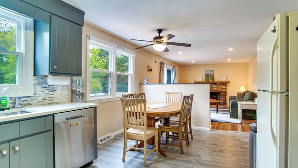 A kitchen with a dining area, wooden chairs, a ceiling fan, and a refrigerator. - Private Hot Tub, Yard & Games Galore: Plymouth Gem (Plymouth)