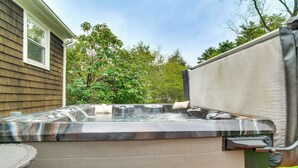 A hot tub with a metallic finish, a wooden deck, and a house in the background. - Private Hot Tub, Yard & Games Galore: Plymouth Gem (Plymouth)