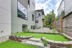 Ein modernes Gebäude mit Innenhof, Steintreppe und einem kleinen Gartenbereich.
