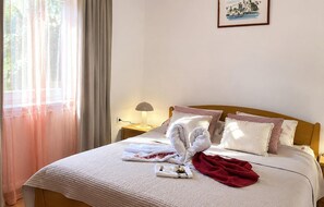A neatly made bed with towels, a lamp, and a painting on the wall. - Lovely apartment in Lumbarda with house sea view (Lumbarda)
