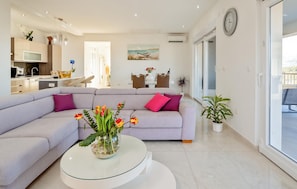 A modern living room with a sofa, a glass coffee table, and a dining area in the background. - Stunning home in Lumbarda (Lumbarda)