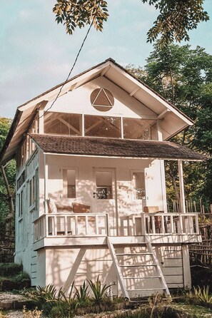 A two-story house with a balcony, a front door, and a window. - Tiny Villa in nature with epic sunrise view (Gili Trawangan, Pemenang)