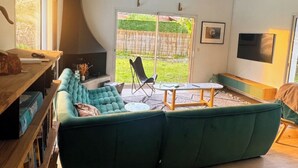 A spacious living room with a large green sectional sofa, a wooden coffee table, and a yellow rug. - Villa with pool near Hossegor beaches (Angresse)