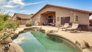 Uma casa com piscina, área de estar externa e um pátio.