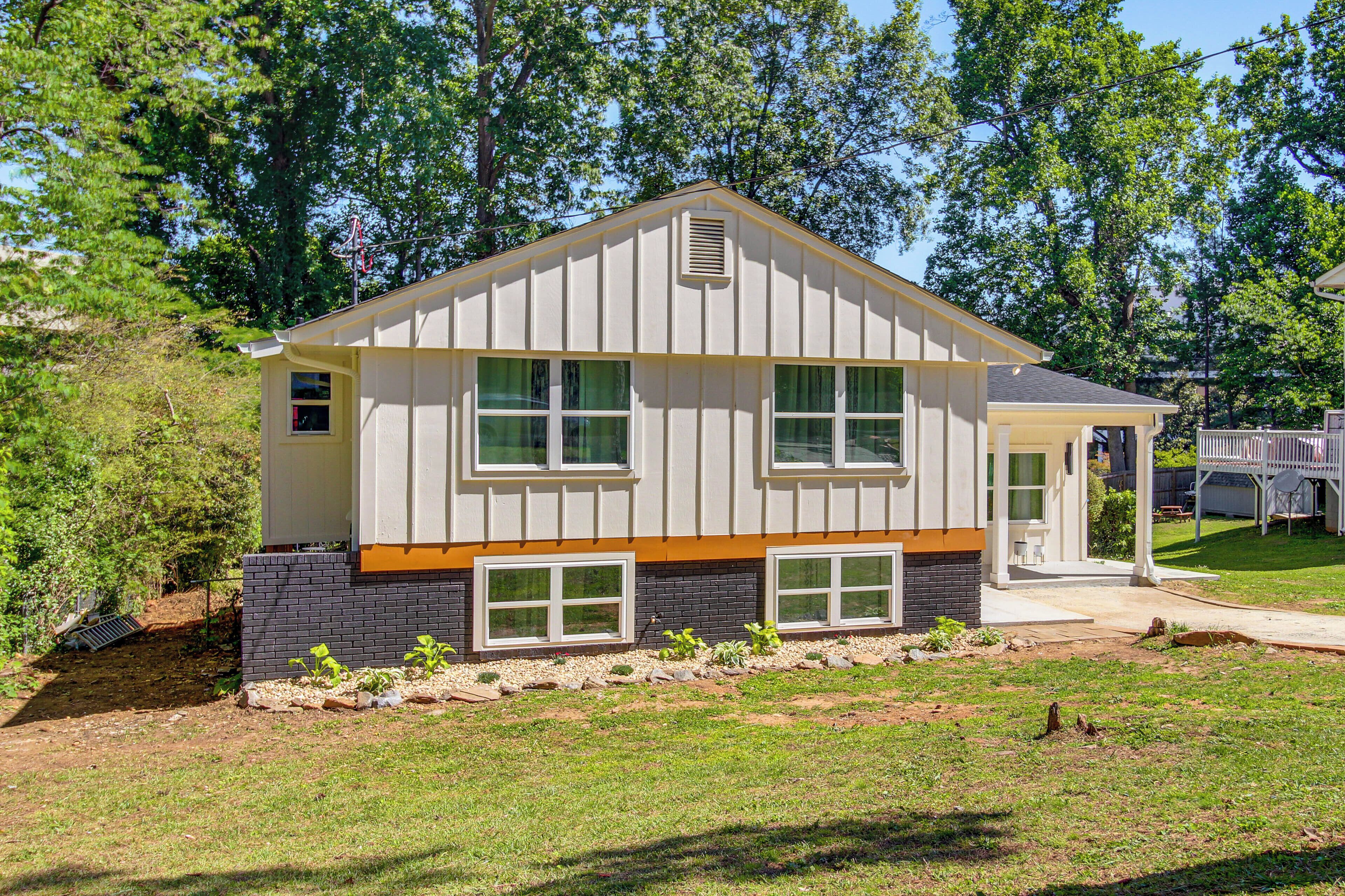 A modern two-story house with a sloped roof, large windows, and a front porch.