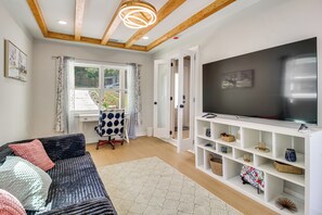 Ein modernes Wohnzimmer mit einer Couch, einem Fernseher und Regalen.