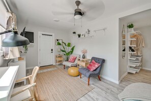 A modern living room with a desk, chair, ottoman, and a ceiling fan. - 1 Mi to Military Base: Cozy Imperial Beach Studio (Imperial Beach)