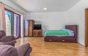 Ein Schlafzimmer mit einem Bett, einem Fernseher, einem Kleiderschrank und einer Couch.