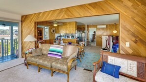 A spacious living room with a sofa, chairs, and a dining area.