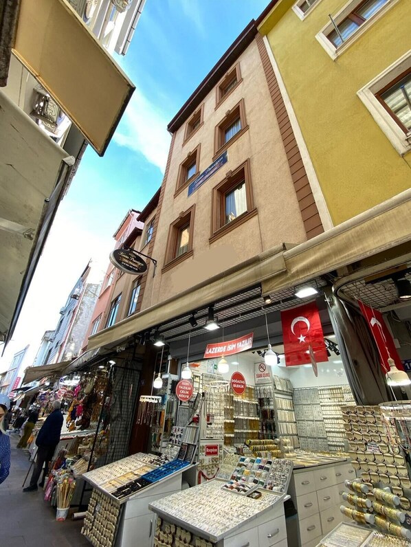 A narrow street with shops on either side, including a jewelry store with glass display cases.