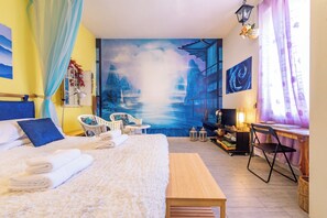 Ein Zimmer mit einem Bett, einem Schreibtisch, einem Stuhl, einer Lampe und einem Bild an der Wand.