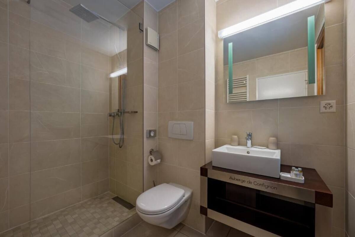 A modern bathroom with a shower, toilet, and sink.
