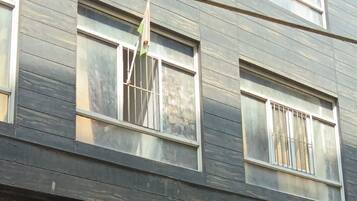 A multi-story building with a sign for 'Hotel Sky Inn' advertising AC rooms.
