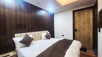 Une chambre d’hôtel avec un lit, une table de chevet et une porte en bois.