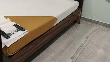 Una habitación de hotel con cama, televisor de pantalla plana, calefacción y cortina.
