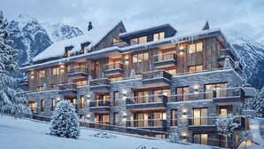 Un lodge a più piani con balconi, facciata in legno e paesaggio innevato.