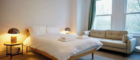 Tabla de planchar con plancha, internet y ropa de cama