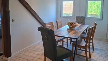 A dining area with a wooden table, chairs, and a window with a view.
