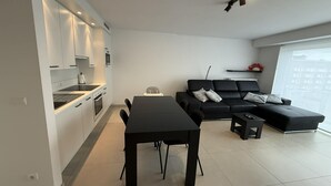Um espaço de estar moderno com cozinha, sala de jantar e área de estar.
