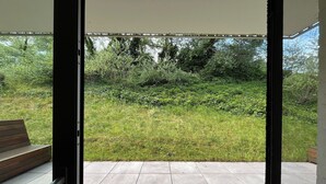 Terrassa oberta amb vista a zona verda i arbres.