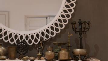 Uma cômoda de madeira com esculturas detalhadas e um espelho grande com moldura decorativa.