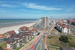 Ein Küstenort mit Hochhäusern, einem Strand und Baukränen.