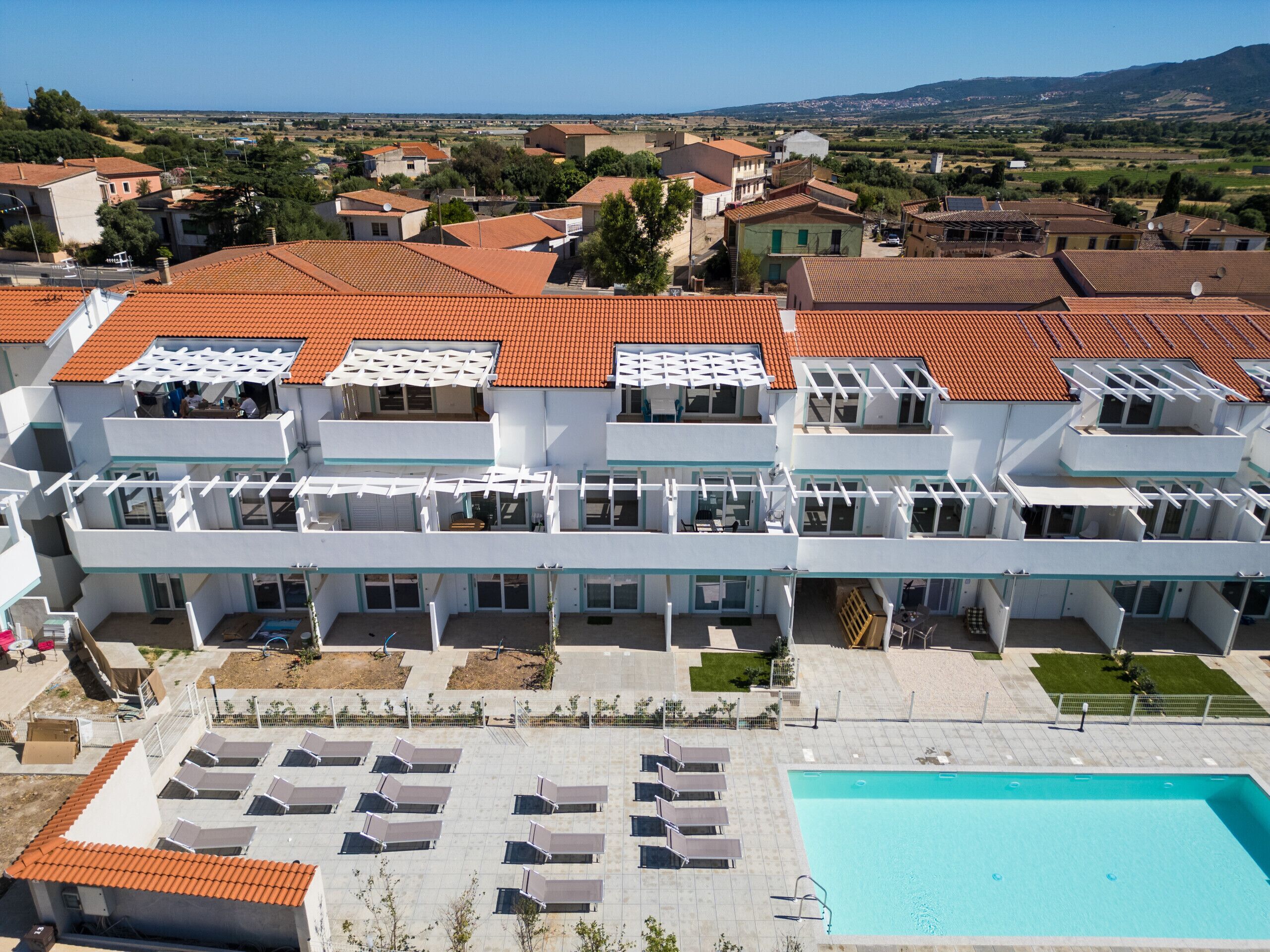 A multi-story hotel with a rooftop pool and outdoor seating area.
