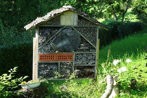 Eine bienenkorbähnliche Struktur mit sechseckigem Design, Holzvertäfelung und einem gestreuten Strohdach.
