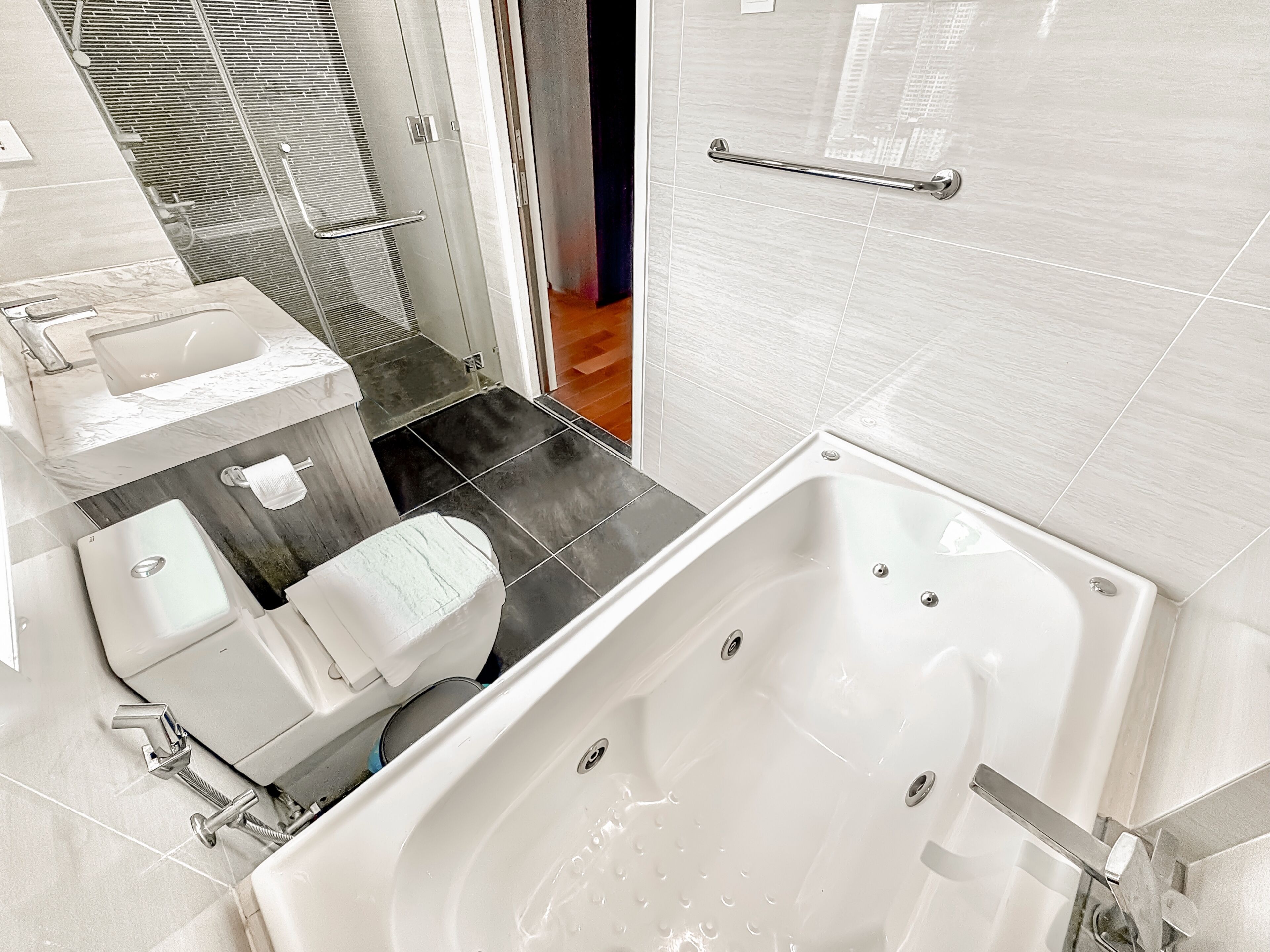 A modern bathroom with a bathtub, toilet, and shower area.
