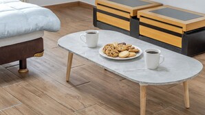 A bed with a headboard, a small table with a plate of cookies and two mugs, and a wooden floor. - Chuncheon O2 Pension (Chuncheon)