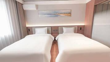 A hotel room with two beds, a painting on the wall, and an air conditioning unit.