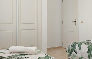 Ein Schlafzimmer mit einem Bett, einer weißen Tür und einer weißen Wand.