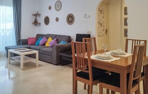 Ein Wohnzimmer mit einer Couch, einem Esstisch mit Stühlen und Wanddekoration.