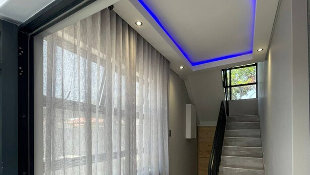 A modern staircase with a glass door leading to a room with a view. - El Pantheon Guest House and Apartments (Cape Town)