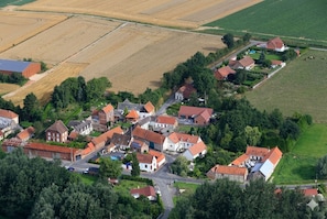 Une vue aérienne d’un village rural avec ses maisons, ses routes et ses champs.