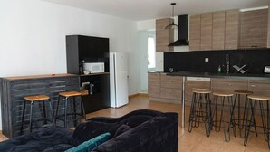 Eine moderne Küche mit Holdekor-Schränken, einer schwarzen Arbeitsplatte und Barhocker.