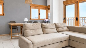 A modern living room with a sofa, a dining table, and a chair. - 2 bedroom beach front apartment in Torrevieja (Torrevieja)
