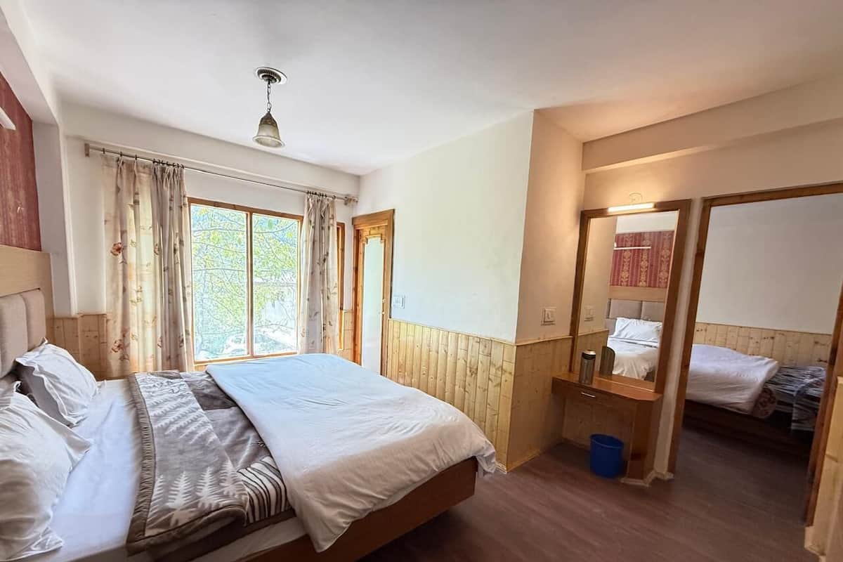Un dormitorio con una cama de madera, una mesita de noche, un espejo y un ventanal con cortinas.