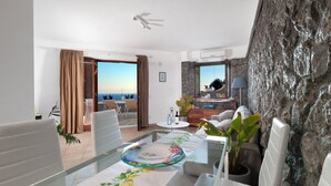 Ein modernes Hotelzimmer mit Balkon, Essbereich und Meerblick.