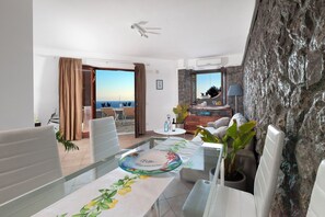 Ein modernes Hotelzimmer mit Balkon, Essbereich und Meerblick.