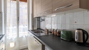 Una cocina con armarios de madera, un lavamanos, un tostador y un hervidor.