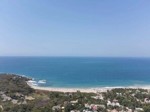 Küste mit Strand, Meer und Wohngebiet.