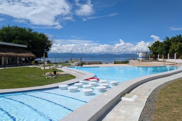 Una piscina al aire libre, sombrillas, sillones reclinables de piscina