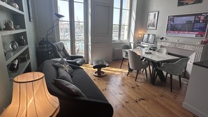 Ein modernes Wohnzimmer mit einer Couch, einem Esstisch und einem Fernseher.