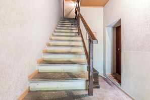 Un escalier avec des marches en bois et des rampes en métal, menant à une porte située en haut.