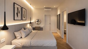 Un dormitorio moderno con cama, lámparas de noche, televisor de pantalla plana y cuadros en la pared.