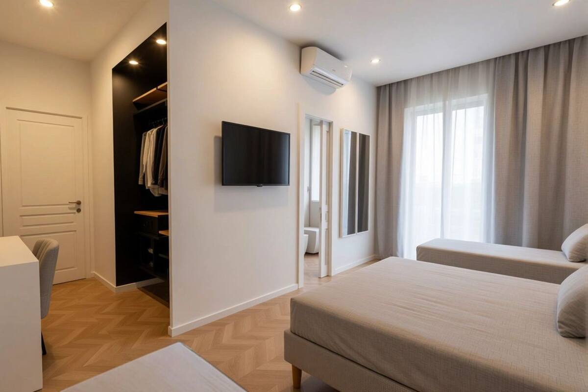 Habitación de hotel con cama, televisión, armario y baño.