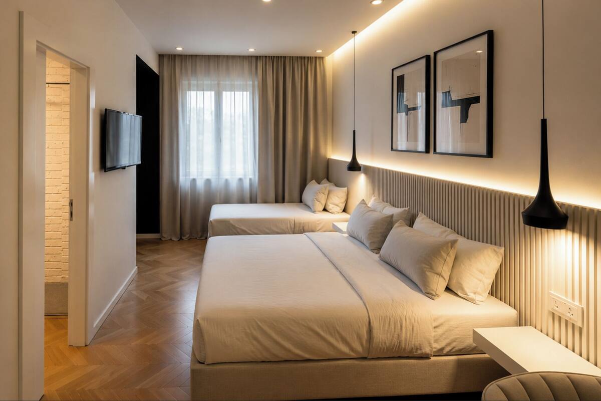 Una habitación de hotel moderna con dos camas, televisión y obras de arte en las paredes.