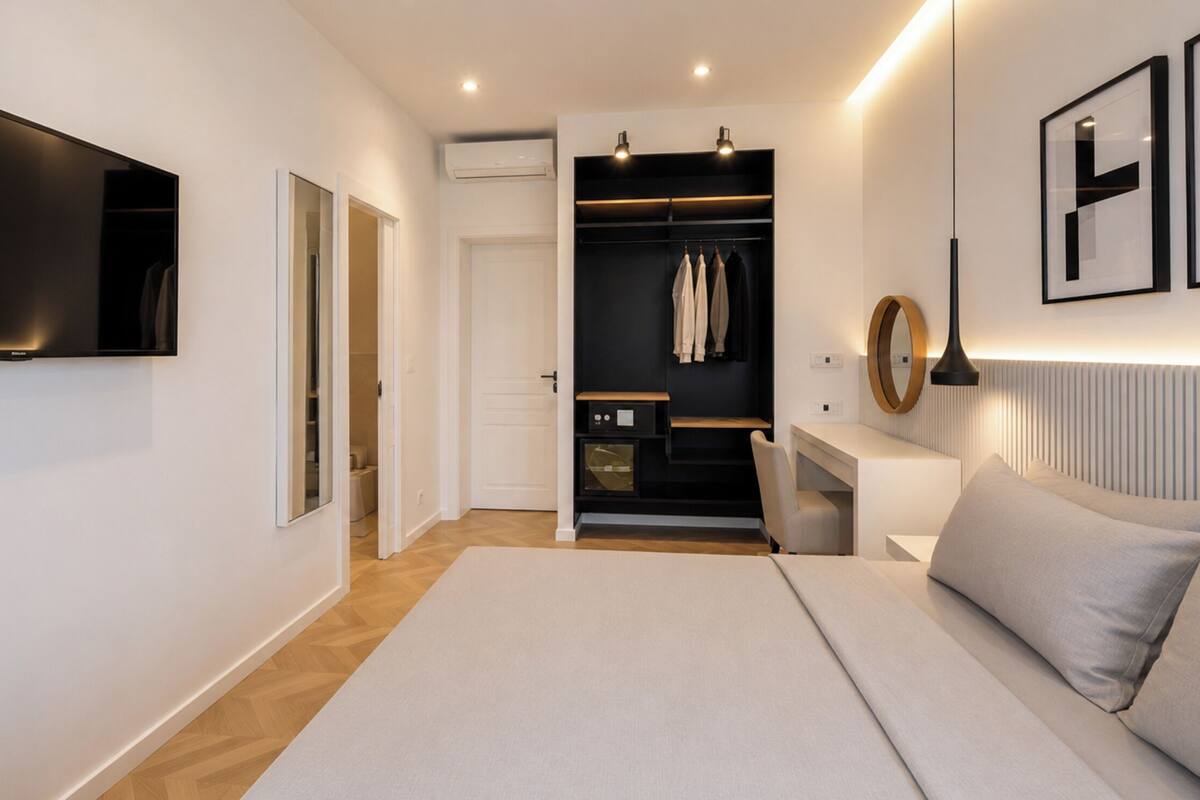 Un dormitorio moderno con cama, mesita de noche y vestidor.