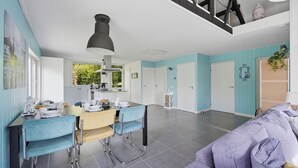 Een moderne keuken met een eethoek, een bank en een plafond met zichtbare balken.